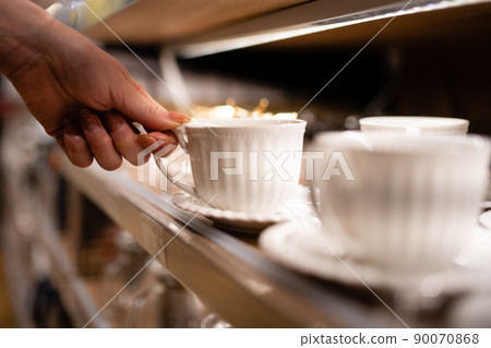 Women's hands choosing a coffee cup Women's hands choosing a coffee cup 90070868