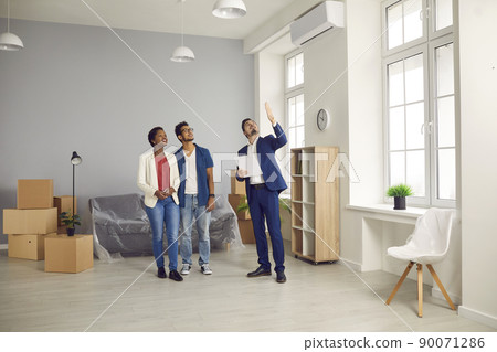 Real estate agent or realtor giving potential buyers tour around new house or flat Real estate agent or realtor giving potential buyers tour around new house or flat 90071286