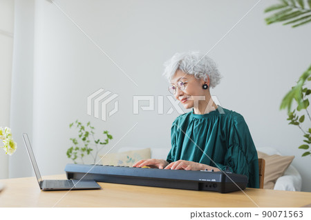 在客廳裡彈鍵盤的灰髮女人 在客廳裡彈鍵盤的灰髮女人 90071563