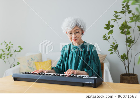 在客廳裡彈鍵盤的灰髮女人 在客廳裡彈鍵盤的灰髮女人 90071568