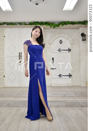 A young and beautiful woman posing in a blue dress A young and beautiful woman posing in a blue dress 90073325