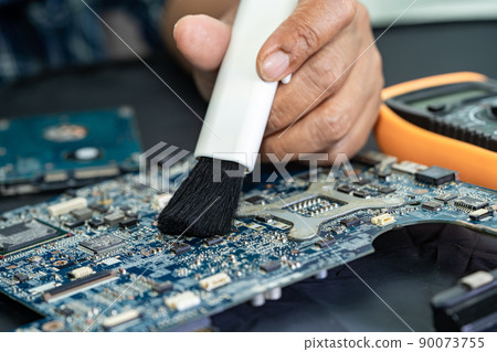 Technician use brush and air blower ball to clean dust in circuit board computer. Repair upgrade and maintenance technology. Technician use brush and air blower ball to clean dust in circuit board computer. Repair upgrade and maintenance technology. 90073755