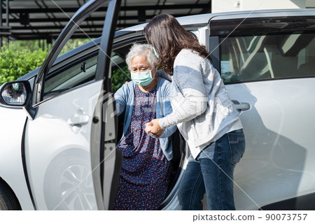 Help and support asian senior or elderly old lady woman patient walk with walker prepare get to her car, healthy strong medical concept. 90073757
