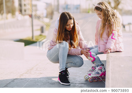 Family in a summer park. Mother in a pink jacket. Little girl with a roller. Family in a summer park. Mother in a pink jacket. Little girl with a roller. 90073893