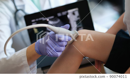 Ultrasound procedures of knee joint of small child in hospital 90074011