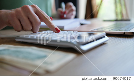 Businesswoman hand using calculator and working with laptop Businesswoman hand using calculator and working with laptop 90074017