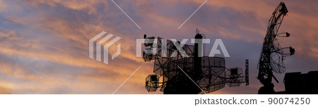 Air defense radars of military mobile anti aircraft systems, modern army industry on the background of the sunset orange sky, Russia 90074250