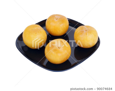Yellow plums on a dark blue plate, isolated on a white background Yellow plums on a dark blue plate, isolated on a white background 90074684
