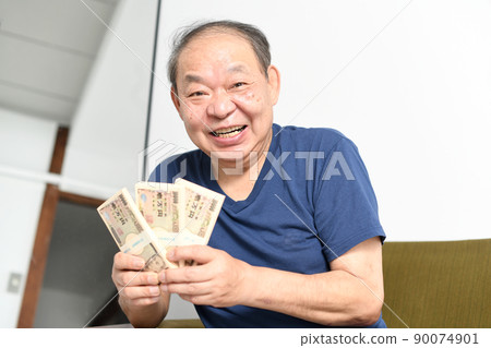 A smiling senior man with a wad of bills 90074901
