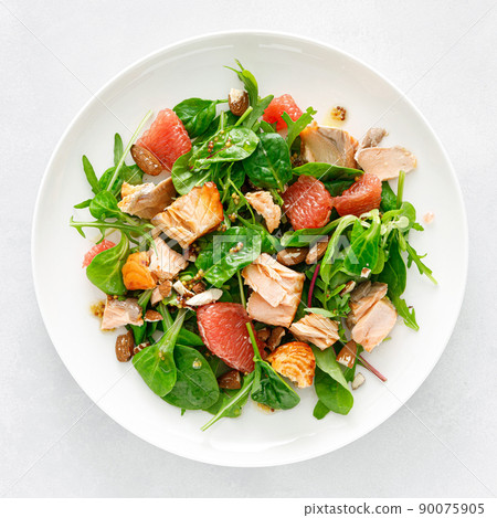 Grilled salmon salad with grapefruit, almonds and salad mix. Top view Grilled salmon salad with grapefruit, almonds and salad mix. Top view 90075905