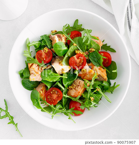 Grilled salmon salad with tomato and salad mix. Top view 90075907