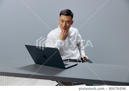 businessmen working on a laptop sitting at a table in the office Gray background 90076896