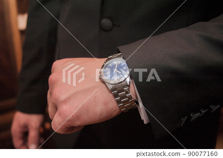 Businessman looking at his watch punctuality Businessman looking at his watch punctuality 90077160