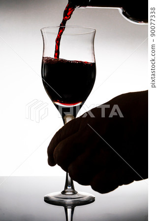 Serving a beautiful glass with a deliciuos red wine. White background, glass cup. Elegance, good taste, style concept. Serving a beautiful glass with a deliciuos red wine. White background, glass cup. Elegance, good taste, style concept. 90077338