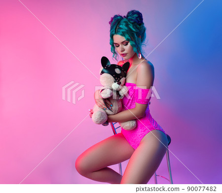 sexy girl with blue hair and pink bodysuit sitting on a bar stool on a neon background sexy girl with blue hair and pink bodysuit sitting on a bar stool on a neon background 90077482
