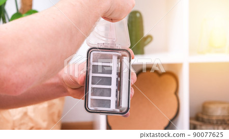 A man shakes out garbage container from a robot 90077625