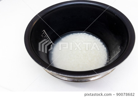 將白米浸泡在黑碗中的水中 90078682