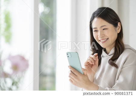 A smiling Arafif woman with a smartphone 90081371