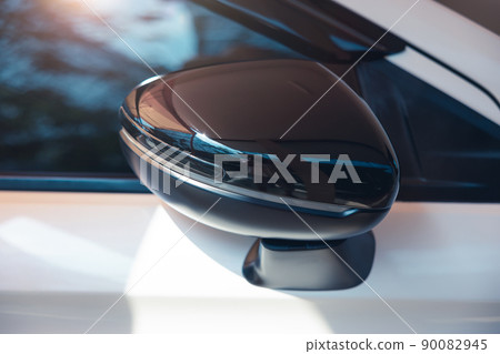 Car side view mirror of white car. 90082945