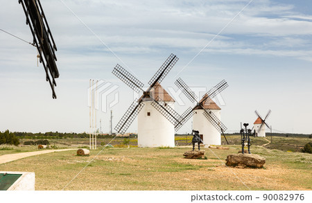 View of Mota del Cuervo with windmills and iron statues of Don Quixote and Sancho Panza 90082976