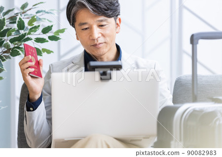 一位商人在出差時在沙發上進行遠程工作 一位商人在出差時在沙發上進行遠程工作 90082983