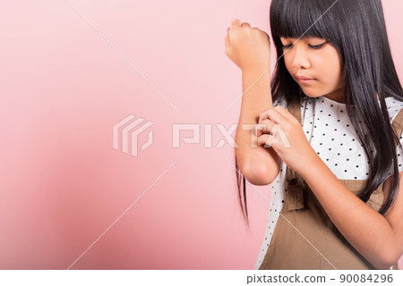 Asian little kid 10 years old scratching itch arm from a mosquito bite Asian little kid 10 years old scratching itch arm from a mosquito bite 90084296