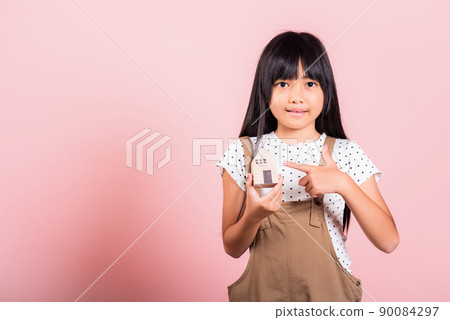 Asian little kid 10 years old hold wood house model on hands Asian little kid 10 years old hold wood house model on hands 90084297