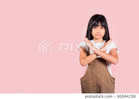 Asian little kid 10 years old showing two hands cross arms say no X sign Asian little kid 10 years old showing two hands cross arms say no X sign 90084298