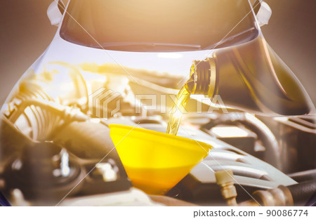 The Engine oil pouring into the car engine with a sunlight and automobile double exposure The Engine oil pouring into the car engine with a sunlight and automobile double exposure 90086774