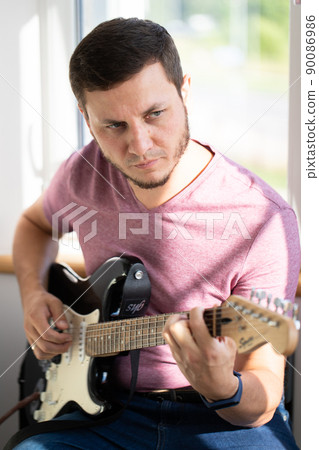 A man plays electric guitar. Macro photo. Vertical photo. A man plays electric guitar. Macro photo. Vertical photo. 90086986