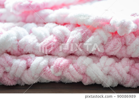 Composition with hand-knitted plaid, the concept of coziness and warmth, home-knitted textiles. Front view. 90086989