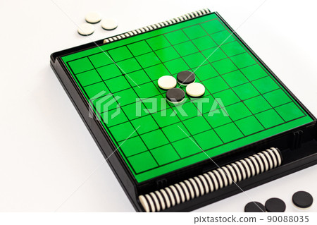 Green Othello board and black and white stones Green Othello board and black and white stones 90088035