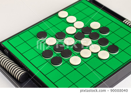 Black and white stones lined up on the green board of Othello Black and white stones lined up on the green board of Othello 90088040