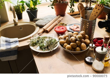 High angle view no people shot of potatoes, rosemary and thyme, cherry tomatoes and other products on kitchen counter High angle view no people shot of potatoes, rosemary and thyme, cherry tomatoes and other products on kitchen counter 90088073