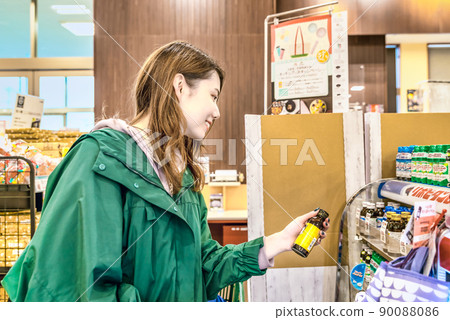 Young woman buying energy drinks at the supermarket Young woman buying energy drinks at the supermarket 90088086