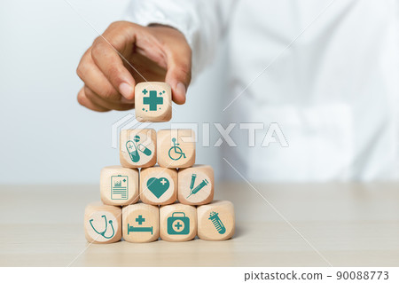 Doctor holding wooden cube blocks stacking with medical icons. treatment and medicine symbol signs. Doctor holding wooden cube blocks stacking with medical icons. treatment and medicine symbol signs. 90088773