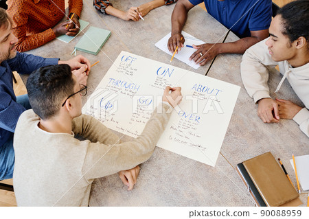 High angle view of multi-ethnic students of international immigrant group learning phrasal verbs during English lesson 90088959