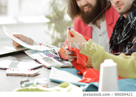 designers discussing new fabric patterns in the Studio. 90089421