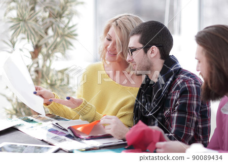 fashionable tailor and a group of designers discussing new models of clothes 90089434