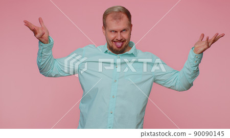 Funny joyful man making playful silly facial expressions, grimacing, fooling around showing tongue Funny joyful man making playful silly facial expressions, grimacing, fooling around showing tongue 90090145