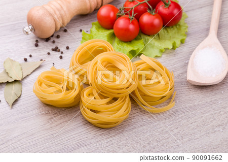 Pasta, tomatoes and pepper on a wooden background 90091662