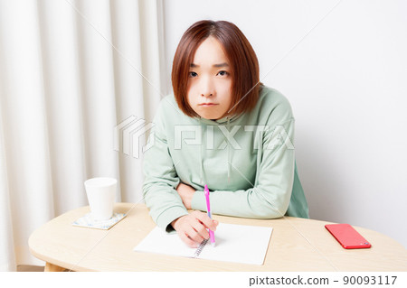 Young woman studying in the living room Young woman studying in the living room 90093117