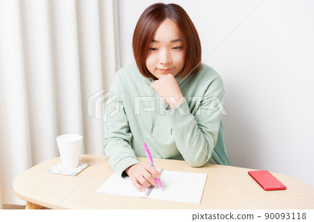 在客廳裡學習的年輕女子 在客廳裡學習的年輕女子 90093118