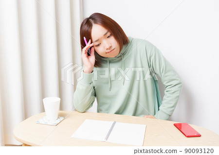 在客廳裡學習的年輕女子 在客廳裡學習的年輕女子 90093120