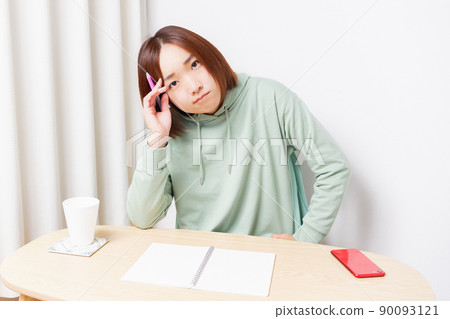 Young woman studying in the living room Young woman studying in the living room 90093121