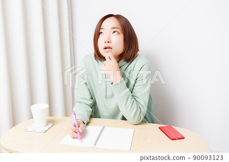 Young woman studying in the living room Young woman studying in the living room 90093123