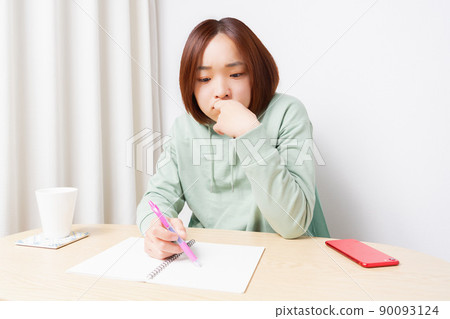 在客廳裡學習的年輕女子 在客廳裡學習的年輕女子 90093124