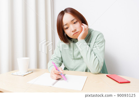 Young woman studying in the living room Young woman studying in the living room 90093125