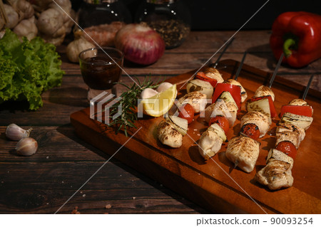 Tasty grilled chicken skewers with barbecue sauce and ingredients on wooden background 90093254