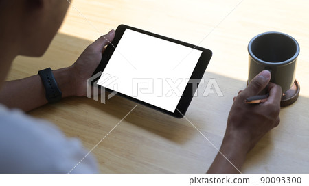 Over older few of man drinking coffee and surfing internet on digital table at home Over older few of man drinking coffee and surfing internet on digital table at home 90093300